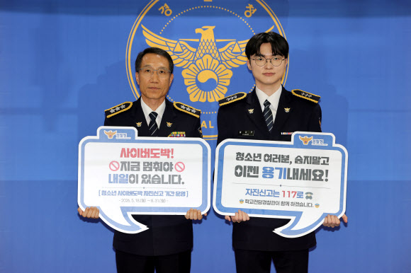 프로게이머 ‘페이커’ 이상혁이 22일 서울 서대문구 경찰청에서 명예경찰 및 사이버도박 예방 홍보대사로 위촉된 뒤 팻말을 들고 유재성 경찰청장 직무대행과 기념사진을 찍고 있다. 2026.7.22 연합뉴스