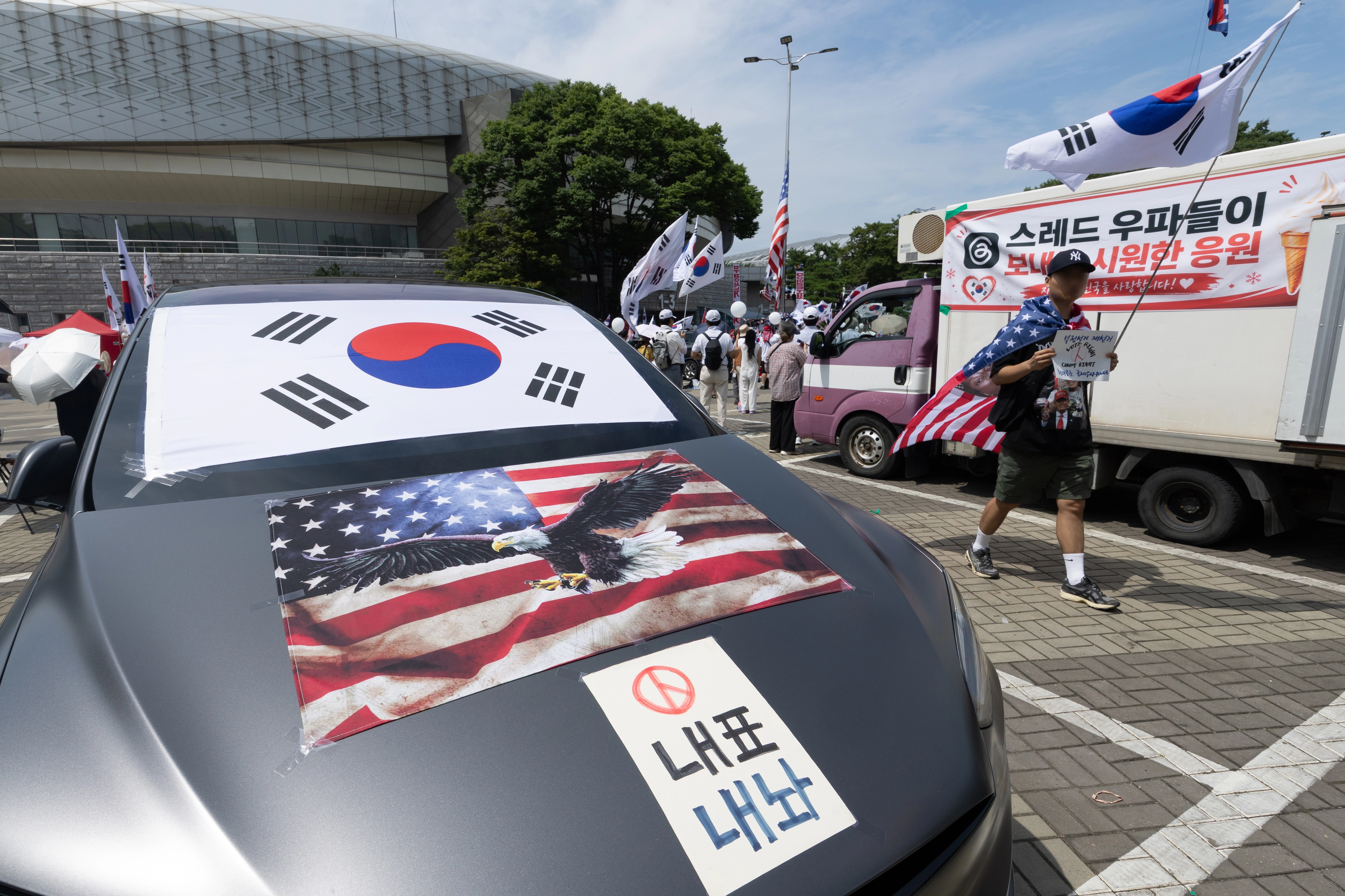 차에 태극기·성조기 붙이고  6·3지방선거 이후 한 달 넘게 개표소 봉쇄 시위가 계속되고 있는 17일 서울 송파구 올림픽공원 핸드볼경기장 앞 시위 현장 차량에 태극기와 성조기가 붙어 있다. 2026.7.17 뉴스1