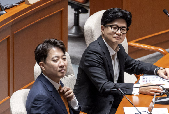 개혁신당 이준석 대표(앞)와 무소속 한동훈 의원이 24일 국회에서 열린 예산결산위원회 전체 회의에 참석해 동료 의원들의 인사말을 듣고 있다. 2026.7.24 연합뉴스