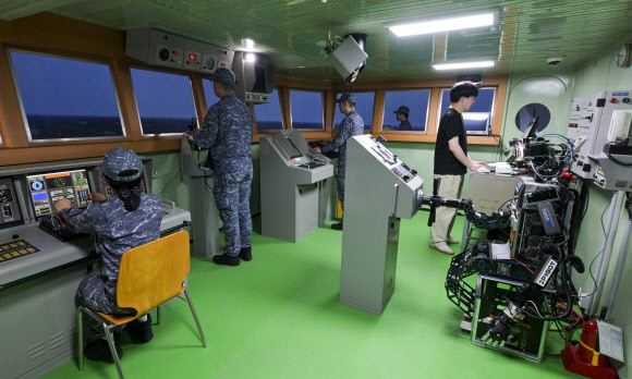 지난 23일 해군교육사령부 조함훈련장에서 해군 최초로 진행된 로봇 승조원 전투실험에서 휴머노이드 로봇 ‘파이봇(PIBOT)’이 이지스구축함 서애류성룡함(DDG) 소속 함교 당직사관의 조함명령에 따라 타수 업무를 수행하고 있다. 2026.7.24  해군 제공