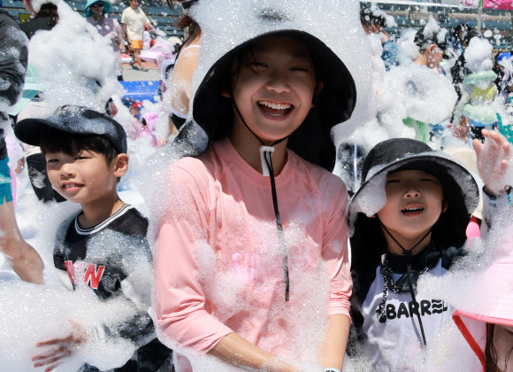27일 부산 남구 용호별빛공원에서 열리고 있는 ‘제4회 유엔남구 물놀이축제’에서 어린이들이 거품을 맞으며 더위를 식히고 있다. 2026.7.27 연합뉴스
