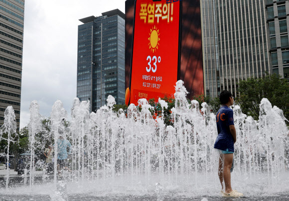 27일 서울 광화문 광장 분수대에서 한 어린이가 물놀이를 하고 있다. 이날 행정안전부는 오후 3시부로 폭염 재난 위기경보를 ‘심각’ 단계로 격상하고 중앙재난안전대책본부를 가동한다고 밝혔다. 2026.7.27 연합뉴스