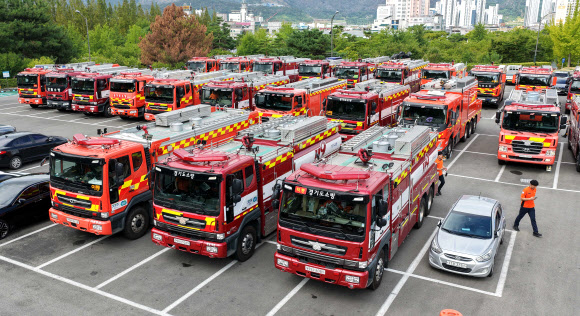 12일 오전 경남 밀양시 교동 밀양종합운동장 주차장에 경기도·강원도 등에서 온 소방차량이 집결해 있다.  정부는 길어지는 폭염과 물 부족을 겪는 경남에 용수공급을 위해 전날 오후 9시를 기해 국가소방동원령을 발령하고 전국 소방력을 투입해 경남지역에 농업·생활용수 공급을 지원한다고 밝혔다. 2026.8.12  연합뉴스