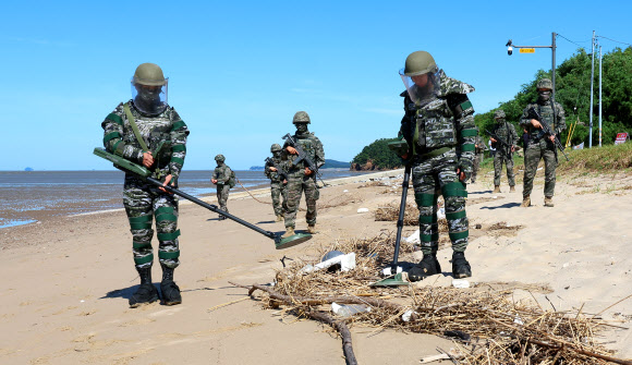 해병대 제2사단 장병들이 12일 인천 강화군 서도면 주문도 뒷장술 해수욕장에서 유실지뢰를 탐색하고 있다. 지난달 말 집중호우로 유실된 것으로 추정되는 북한 유실지뢰가 인천 강화군 일대 해안에서 잇따라 발견되고 있다. 2026.8.12  연합뉴스
