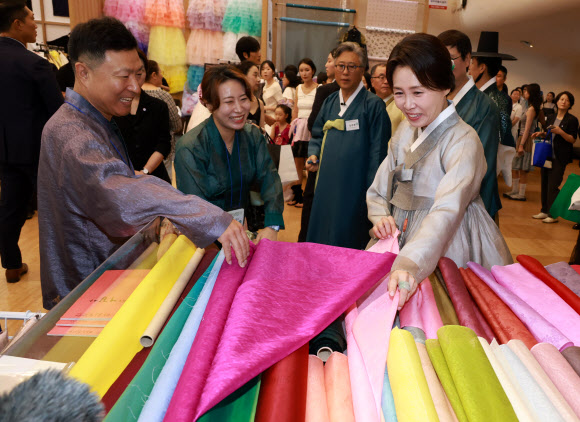 김혜경 여사가 14일 서울 중구 동대문디자인플라자에서 열린 한복박람회 ‘2026 한복상점’에서 원단을 보고 있다. 2026.8.14  연합뉴스