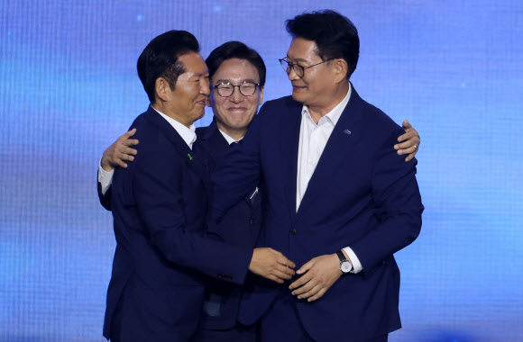 더불어민주당 김민석 신임 당 대표가 17일 대전 컨벤션센터에서 열린 제3회 더불어민주당 정기 전국당원대회에서 당 대표로 선출된 뒤 정청래, 송영길 후보와 인사하고 있다. 2026.8.17  연합뉴스