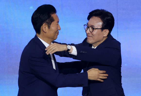 더불어민주당 김민석 신임 당 대표가 17일 대전 컨벤션센터에서 열린 제3회 더불어민주당 정기 전국당원대회에서 당 대표로 선출된 뒤 정청래 후보와 포옹하고 있다. 2026.8.17  연합뉴스