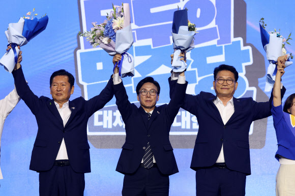 더불어민주당 김민석 신임 당 대표가 17일 대전 컨벤션센터에서 열린 제3회 더불어민주당 정기 전국당원대회에서 당 대표로 선출된 뒤 정청래(왼쪽), 송영길 후보와 함께 당원들에게 인사하고 있다. 2026.8.17  공동취재