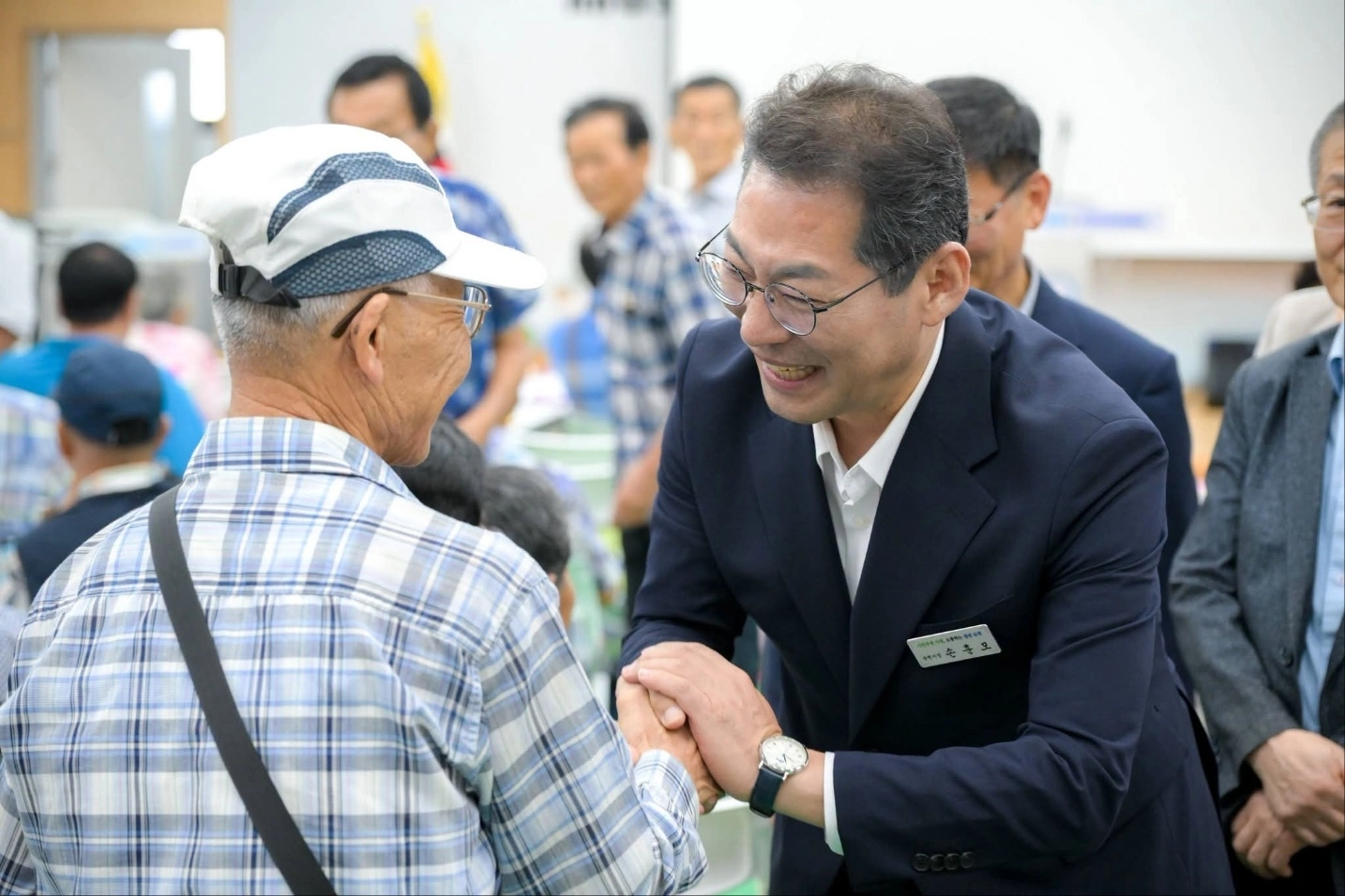 손훈모 시장이 시민과 손을 맞잡고 있다.