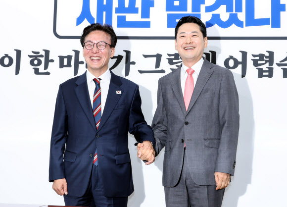 더불어민주당 김민석 대표(왼쪽)와 국민의힘 장동혁 대표가 24일 국회에서 만나 기념 촬영을 하고 있다. 이날 만남은 김민석 대표가 취임 인사차 방문해 성사됐다. 2026.8.24 연합뉴스