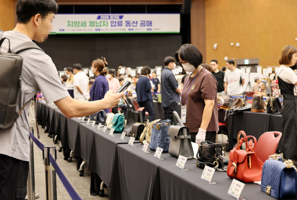 27일 경기 고양 킨텍스 제1전시장 그랜드볼룸에서 열린 ‘2026년 지방세 체납자 압류동산 공매’에서 참여자들이 입찰 물품들을 살펴보고 있다.  이날 전체 공매 물품은 경기도 내 21개 시군이 고액·상습 체납자로부터 압류한 명품가방, 명품시계, 귀금속 등 총 620점이다. 2026.8.27 연합뉴스