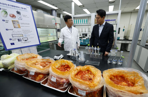 오세훈 서울시장이 31일 서울 서초구 보건환경연구원에서 박주성 보건환경연구원장에게 중국산 김치 관련 안전성 검사 현황에 대해 보고를 받고 있다. 2026.8.31  공동취재