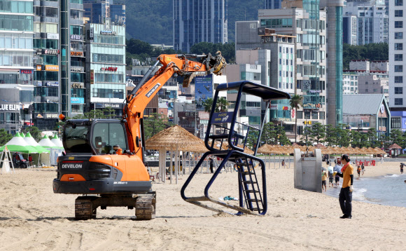 1일 부산 수영구 광안리해수욕장에서 구청 관계자들이 중장비를 동원해 해수욕장 망루를 철거하고 있다.  해운대해수욕장을 제외한 송정·송도·광안리·다대포·일광·임랑 등 부산지역 6개 해수욕장은 지난달 31일 폐장했다. 2026.9.1 연합뉴스