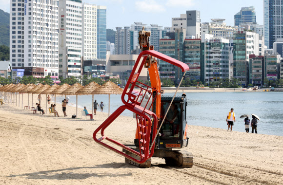 1일 부산 수영구 광안리해수욕장에서 구청 관계자들이 중장비를 동원해 해수욕장 망루를 철거하고 있다.  해운대해수욕장을 제외한 송정·송도·광안리·다대포·일광·임랑 등 부산지역 6개 해수욕장은 지난달 31일 폐장했다. 2026.9.1 연합뉴스