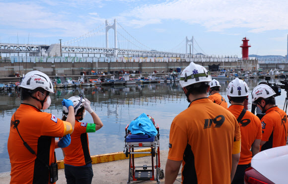 2일 오후 부산 앞바다에서 전복된 예인선에 타고 있던 선원이 구조되면 이송을 대기하는 소방대원들이 수영구 민락항에서 대기하고 있다. 8명이 탄 예인선이 오륙도 앞바다에서 전복돼 현재 1명이 사망하고 1명이 구조된 상태다. 해경은 실종된 6명을 수색하고 있다. 2026.9.2 연합뉴스