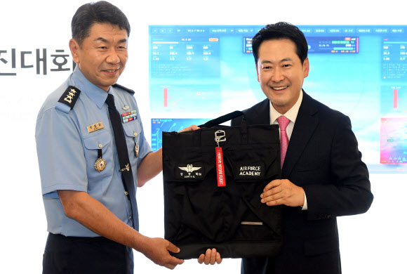 국민의힘 장동혁 대표가 7일 충북 청주시 상당구 공군사관학교를 방문해 AI 파일럿 매치 시뮬레이션 시연을 본 뒤 박흥재 공군사관학교장에게 방문 기념 헬멧백을 전달받고 있다. 2026.9.7. 국회사진기자단