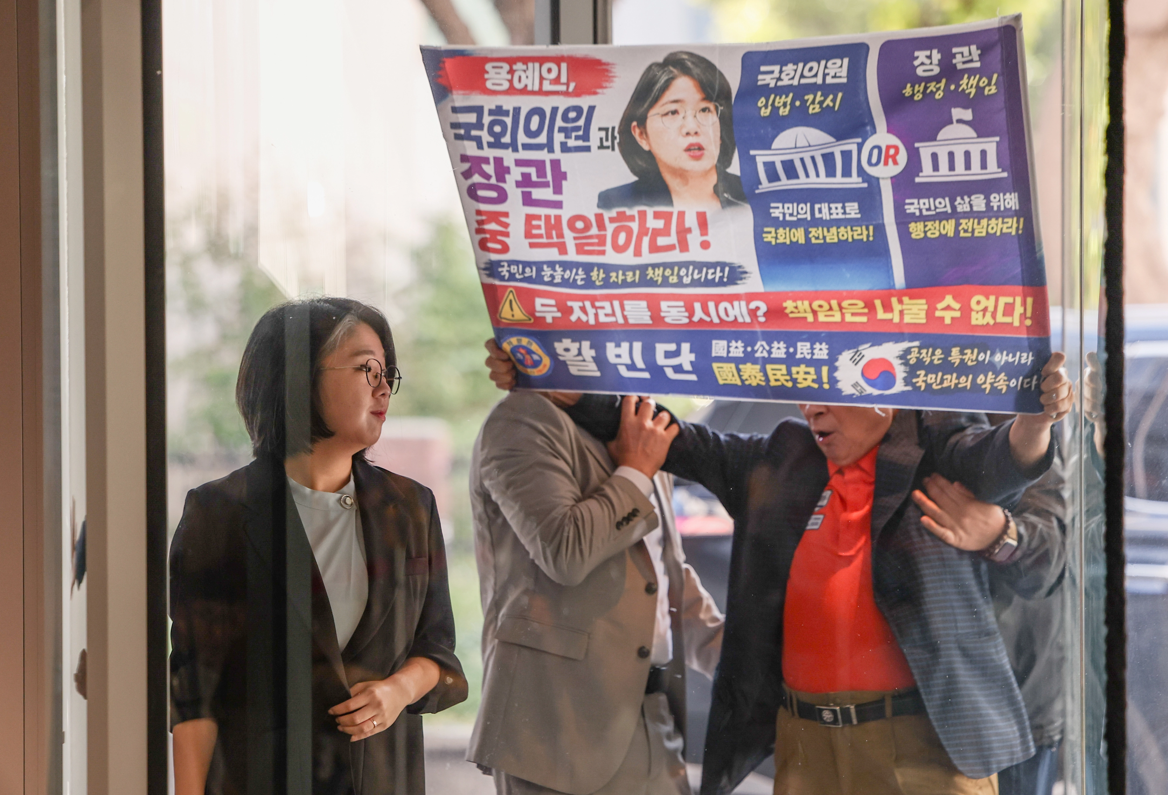 용혜인 성평등가족부 장관 후보자가 11일 오전 서울 서대문구 한국청소년활동진흥원에서 ‘국회의원과 장관 중 택일하라’고 적힌 현수막을 들고 항의하는 시민을 뒤로한 채 인사청문회 준비 사무실로 출근하고 있다. 2026.09.11. 뉴시스