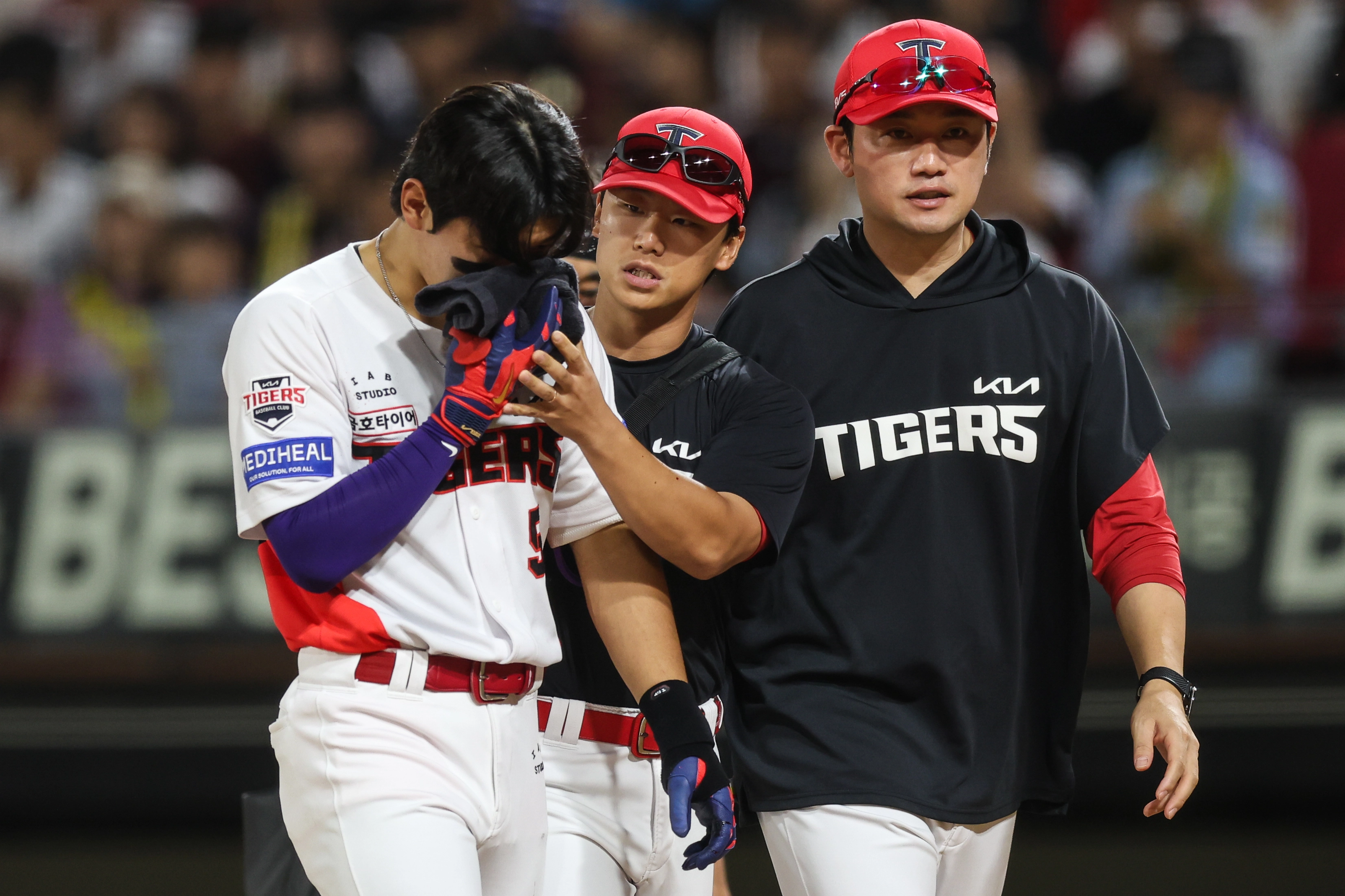 KIA 김도영(왼쪽)이 지난 9일 자신의 번트 타구에 얼굴을 맞아 코피를 흘리며 더그아웃으로 향하고 있다.       KIA 타이거즈 제공