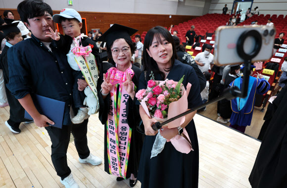 14일 대구시교육청 행복관에서 열린 ‘대구내일학교 졸업식’에서 한 졸업생이 손자와 아들, 딸 등 가족과 함께 셀카를 찍고 있다. 대구내일학교는 배움의 기회를 놓친 성인에게 초·중학교 학력을 인정받을 수 있도록 돕는 무료 교육과정이다. 2026.9.14 연합뉴스