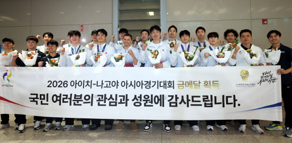 12년 만에 아시안게임 금메달을 획득한 남자 농구대표팀 니콜라이스 마줄스 감독과 선수들이 21일 인천공항을 통해 귀국한 뒤 기념촬영하고 있다. 2026.9.21  연합뉴스