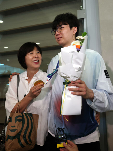 12년 만에 아시안게임 금메달을 획득한 남자 농구대표팀의 이현중이 21일 인천공항을 통해 귀국한 뒤 어머니 성정아 대한민국 농구협회 이사와 환하게 웃고 있다. 2026.9.21 연합뉴스
