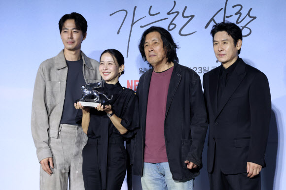 배우 조인성(왼쪽부터), 조여정, 이창동 감독, 설경구가 21일 서울 용산구 CGV 용산아이파크몰에서 열린 영화 ‘가능한 사랑’ 시사회?기자간담회에서 베니스국제영화제 ‘은사자상’트로피를 들고 포즈를 취하고 있다. 2026.9.21  연합뉴스