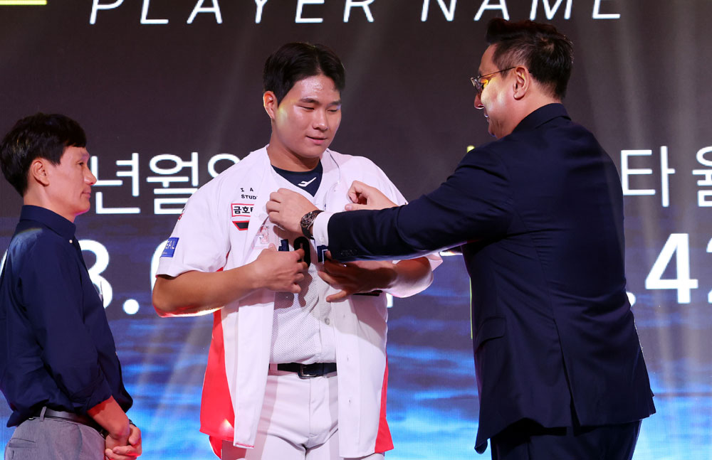 21일 오후 서울 송파구 롯데호텔 월드 크리스탈볼룸에서 열린 2027 KBO 신인 드래프트, KIA 심재학 단장이 전체 3순위로 경남고 이호민를 지명한 후 유니폼을 입혀주고 있다. 2026.09.21. 뉴시스