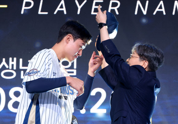 21일 서울 롯데호텔 월드에서 열린 2027 KBO 신인 드래프트.   1라운드 6순위로 NC 다이노스 지명을 받은 경남고 박보승이 유니폼과 모자를 받고 있다. 2026.9.21  연합뉴스