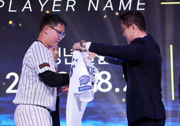 21일 오후 서울 송파구 롯데호텔 월드 크리스탈볼룸에서 열린 2027 KBO 신인 드래프트, 삼성 이종열 단장이 전체 7순위로 광주진흥고 김민훈을 지명한 후 유니폼을 입혀주고 있다. 2026.09.21. 뉴시스