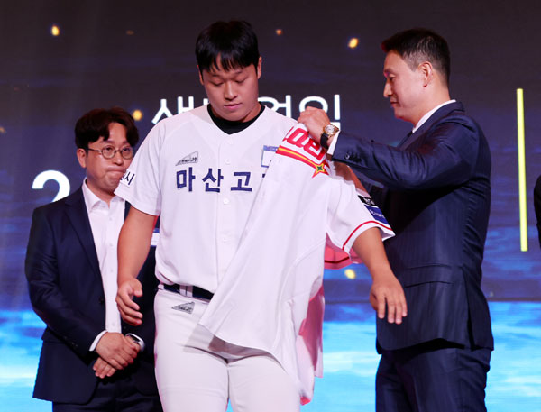 21일 오후 서울 송파구 롯데호텔 월드 크리스탈볼룸에서 열린 2027 KBO 신인 드래프트, SSG랜더스 김재현 단장이 전체 8순위로 마산고 이윤성을 지명한 후 유니폼을 입혀주고 있다. 2026.09.21. 뉴시스