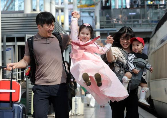 추석을 앞둔 23일 서울역에서 한복을 곱게 차려입은 어린이가 부모님의 손을 잡고 열차를 타러 가고 있다. 2026.9.23 연합뉴스