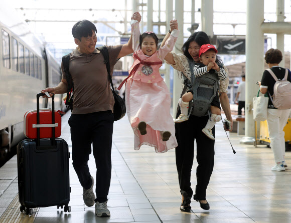 추석을 앞둔 23일 서울역에서 한복을 곱게 차려입은 어린이가 부모님의 손을 잡고 열차를 타러 가고 있다. 2026.9.23 연합뉴스
