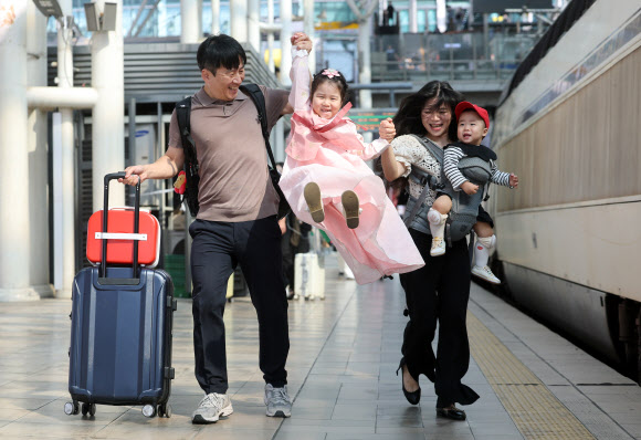 추석을 앞둔 23일 서울역에서 한복을 곱게 차려입은 어린이가 부모님의 손을 잡고 열차를 타러 가고 있다. 2026.9.23 연합뉴스