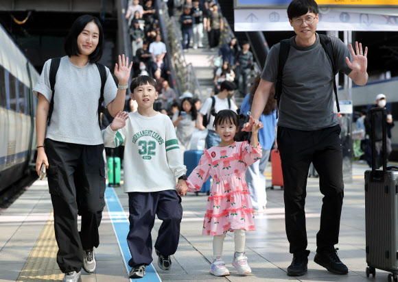 추석을 앞둔 23일 서울역에서 귀성길 한 가족이 열차를 타러 가며 인사하고 있다. 2026.9.23 연합뉴스