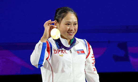 23일 일본 나고야 중소기업진흥회관에서 열린 2026 아이치?나고야 아시안게임 역도 여자 49㎏ 결승에서 금메달을 획득한 북한 리성금이 시상대에 올라 메달을 들어 보이고 있다. 리성금은 인상 2차 시기 94kg, 용상 2차 시기 121kg를 성공하며 총합 215kg으로 금메달을 획득했다. 2026.9.23 연합뉴스