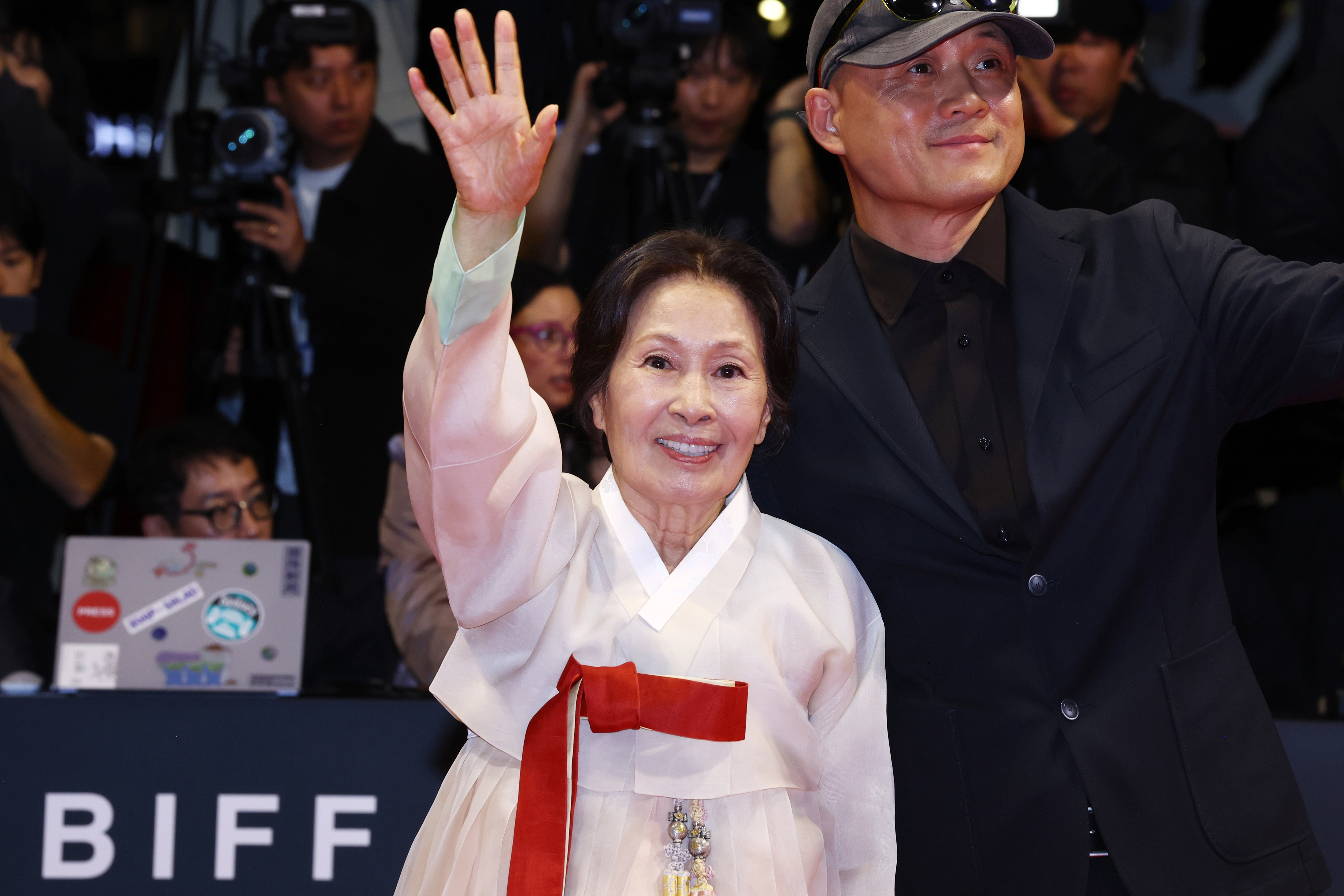 배우 김혜자가 6일 오후 부산 해운대구 영화의전당에서 열린 제31회 부산국제영화제 개막식 레드카펫 행사에서 관람객들을 향해 손을 흔들고 있다. 오른쪽은 김혜자 주연의 영화 ‘여전히 찬란하게’의 송일곤 감독. 2026.10.6 연합뉴스