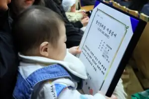 thumbnail - ‘출산장려금 지급증서’ 보는 아기