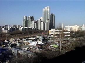 양재천을 사이에 두고 타워팰리스와 마주보는포이동 판자촌.