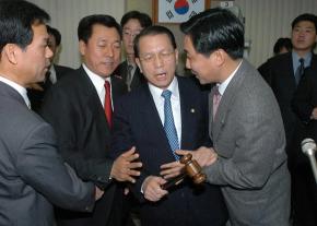 왜 이러시나 김기춘(가운데) 국회 법사위원장이 10일 오전 금감위에서 의사봉을 들고 청문회를 진행하려 하자 열린우리당 송석찬(왼쪽)·이종걸 의원이 양쪽에서 제지하고 있다. 오정식기자 oosing@