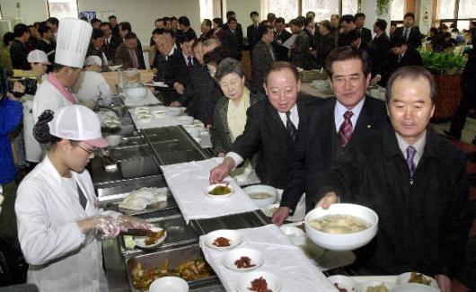 정부 과천청사 구내식당에서 허상만(맨 오른쪽) 농림부 장관 등 공무원들이 점심식사를 위해 삼계탕을 배식받고 있다.
 서울신문 포토라이브러리