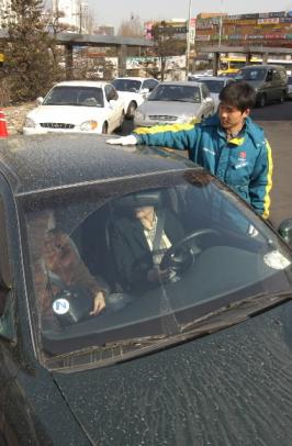 "아니벌써 황사가" 15일 서울 서초구 반포동의 한 주유소에서 직원이 황사 먼지로 얼룩진 승용차를 닦고 있다. 이호정 기자 Hojeong@