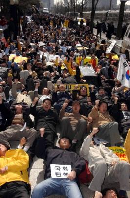 노무현 대통령의 탄핵안이 가결된 12일 서울 여의도 국회앞에 모인 2000여명의 노사모 회원들이 도로에 누워 탄핵철회를 외치고 있다.  도준석기자 pado@