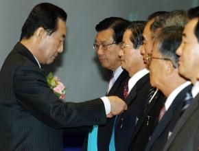 고건 권한대행이 17일 오전 코엑스에서 열린 제31회 상공의 날 기념식에 참석, 박정인 현대모비스회장에게 금탑 산업훈장을 달아주고 있다.   사진공동취재단