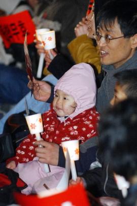 전국에서 한파주의보가 내려진 가운데 17일 밤 서울 광화문 동화면세점 앞에서 열린 촛불집회에서 한 아버지가 아이를 끌어안고 '탄핵무효'가 적힌 종이를 흔들고 있다. 이언탁기자 utl@
