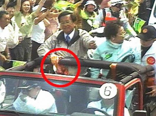 피격순간 타이완 총통선거를 하루 앞둔 19일 천수이볜 (무지개차 왼쪽) 총통이 피격직후 사실을 모른채 유세를 계속하고 있다. 오른쪽은 무릎에 총격을 입은 뤼슈롄 부총통. 붉은 동그라미는 총상에서 나온 피가 점퍼를 적신 모습. CNN촬영