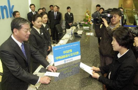 *황영기(왼쪽) 신임 우리은행장이 25일 취임식을 마친 뒤 서울 회현동 본점 영업부에서 고객들을 상대로 모기지론(장기주택담보대출)에 대해 상담하고 있다.  이호정기자 hojeong@