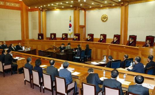 지난 30일 열린 노무현 대통령 탄핵심판 사건 첫 변론에서 윤영철(재판관석 가운데) 헌법재판소장과 재판관들이 왼쪽 소추위원측과 오른쪽 대통령대리인단측을 둘러보며 변론을 진행하고 있다. 서울신문 포토라이브러리