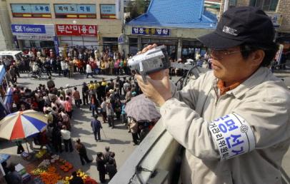 지난 6일 경북 의성 안계장터에서 열린 국회의원 후보 연설회에서 지역 선관위 직원이 선거운동원들의 일거수일투족을 캠코더에 담고 있다. 서울신문 포토라이브러리