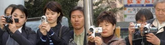 "잘찍어야지"  8일 서울 여의도 백화점 앞에서 열린 한 정당의 선거 유세에서 시민들이 카메라를 통해 유세 풍경을 담고있다.