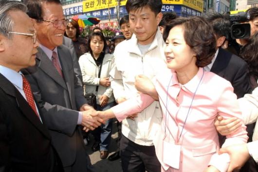 성남서 민주당 추미애(오른쪽) 선거대책위원장이 9일 보좌진들의 부축을 받으며 경기도 성남 모란시장 지원유세에 나서 시민들과 악수를 나누고 있다. 오정식기자 oosing@